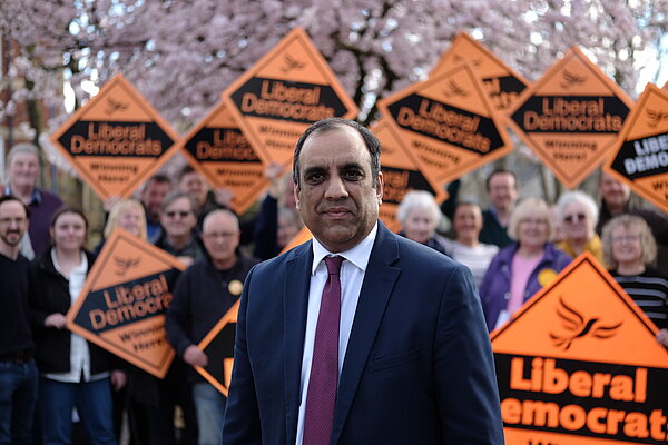 Shaffaq Mohammed in front of a group of Sheffield Lib Dems holding orange diamonds