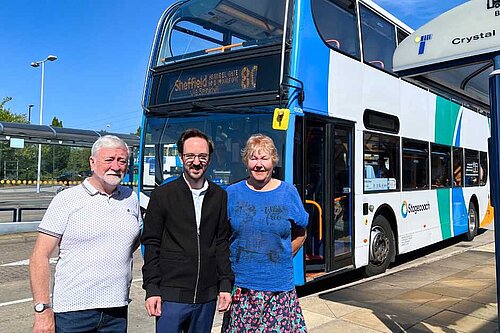 Cllr Kurtis Crossland in front of a bus with ward colleagues Cllr Bob McCann and Cllr Ann Woolhouse