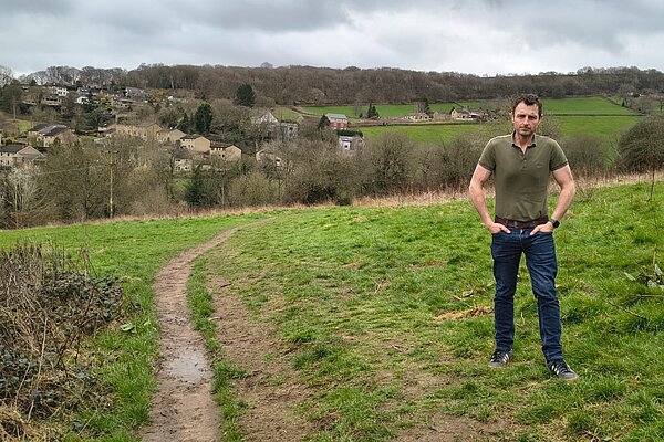 Stuart in front of a green field