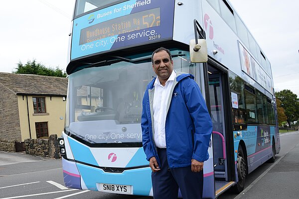 Cllr Shaffaq Mohammed in front of a bus